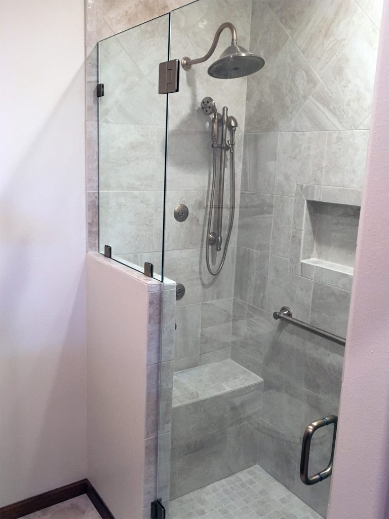 Light stone tile shower with glass surround