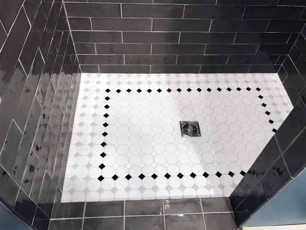 Dark gray shower tiles with light floor tiles