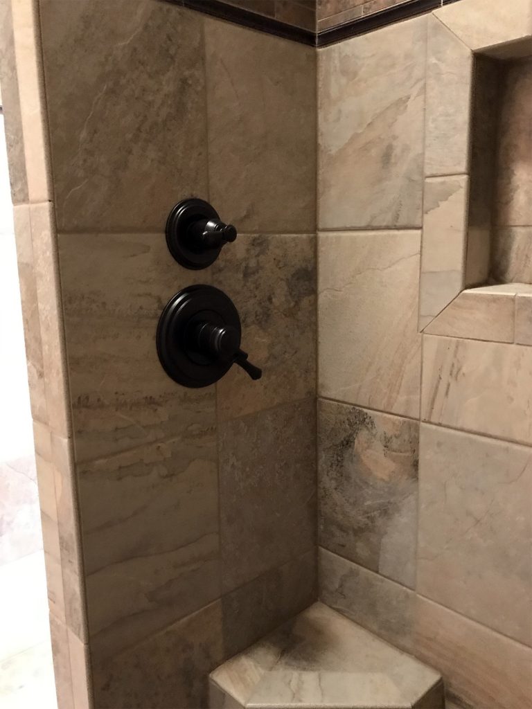 Light stone shower with dark shower fixtures