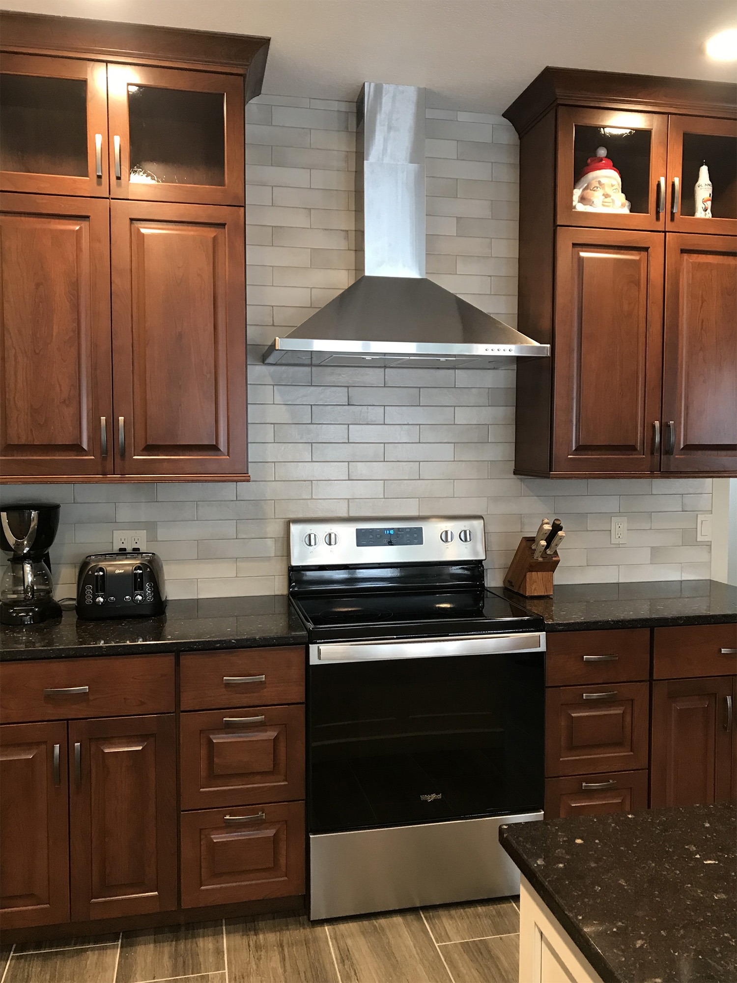 Wood kitchen cabinets with stainless hood and oven